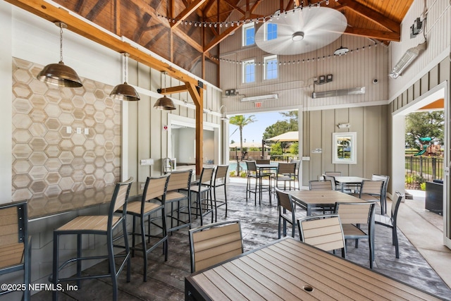 interior space featuring ceiling fan, outdoor dry bar, a patio, and outdoor dining space