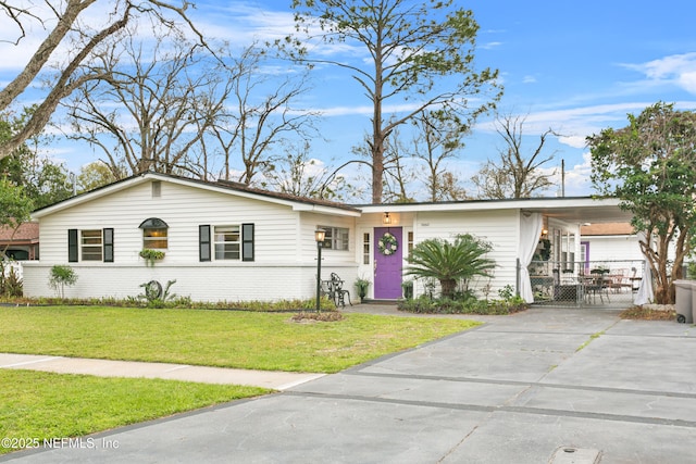 ranch-style home with concrete driveway, a front lawn, an attached carport, and brick siding