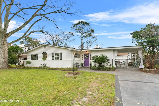 ranch-style home featuring a carport, a front lawn, concrete driveway, and brick siding