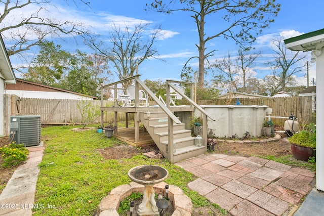 view of yard featuring a fenced in pool, central AC, and a fenced backyard