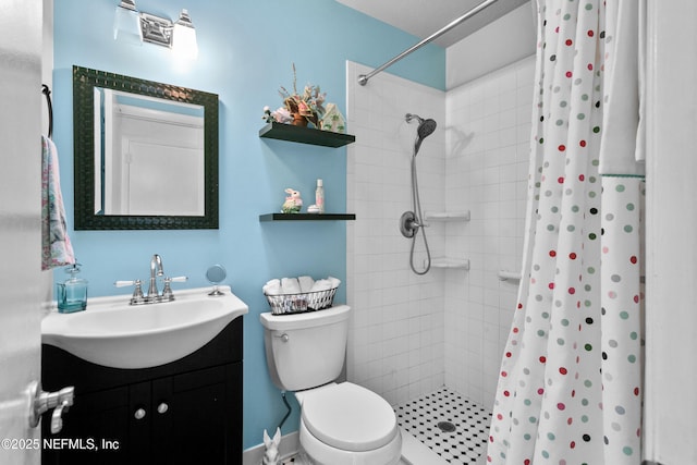 bathroom with tiled shower, vanity, and toilet