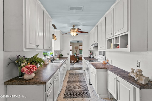 kitchen featuring under cabinet range hood, a sink, white cabinets, dark countertops, and white electric range oven