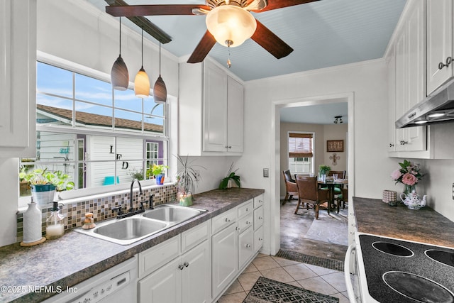 kitchen with dark countertops, white appliances, white cabinetry, and a sink