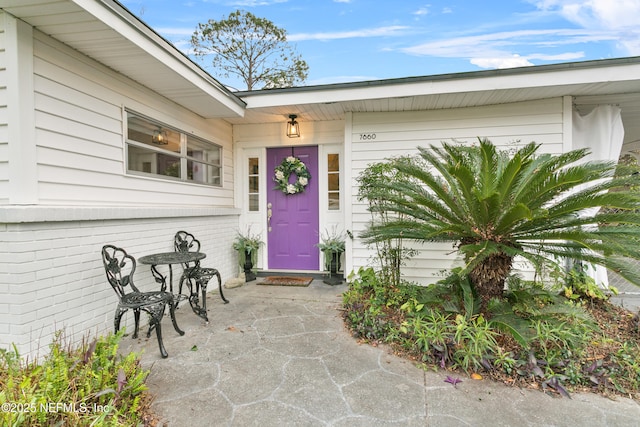 property entrance featuring brick siding