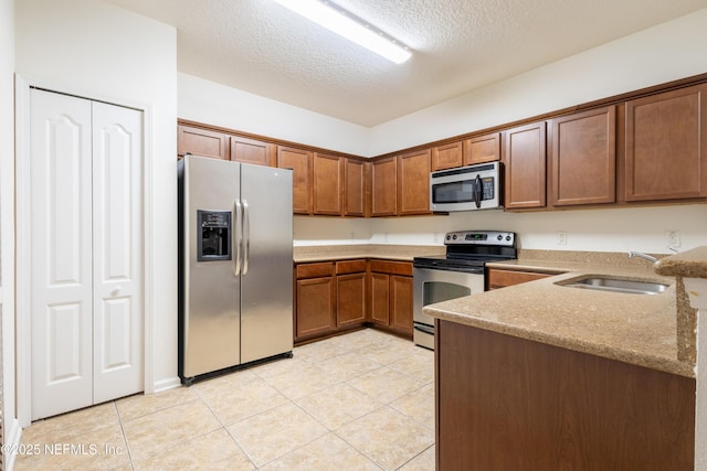 4908 Key Lime Dr Unit 301, Jacksonville, FL 32256 - kitchen with light stone countertops, light tile patterned floors, appliances with stainless steel finishes, a textured ceiling, and a sink