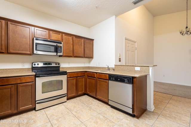 4908 Key Lime Dr Unit 301, Jacksonville, FL 32256 - kitchen featuring brown cabinets, a sink, stainless steel appliances, a peninsula, and light countertops
