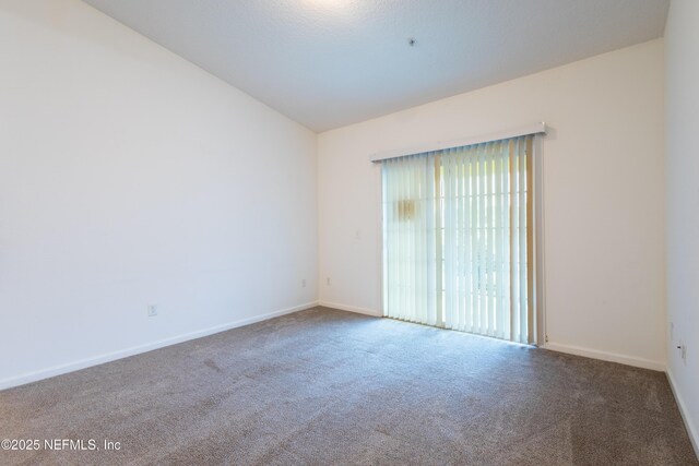 4908 Key Lime Dr Unit 301, Jacksonville, FL 32256 - empty room with vaulted ceiling, baseboards, and carpet floors