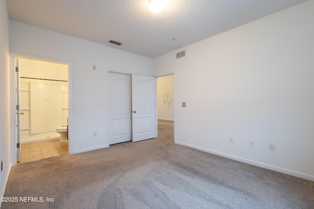 4908 Key Lime Dr Unit 301, Jacksonville, FL 32256 - unfurnished bedroom with ensuite bath, carpet, visible vents, and a textured ceiling