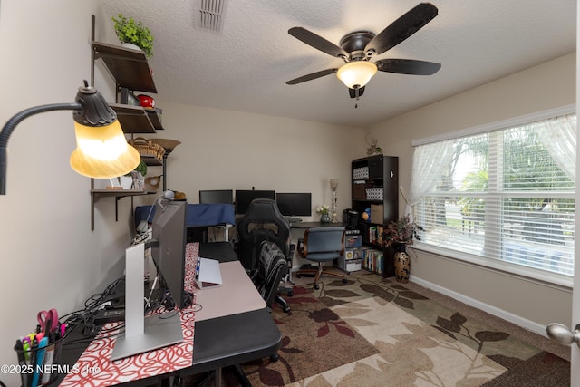 office featuring carpet, visible vents, a textured ceiling, and baseboards