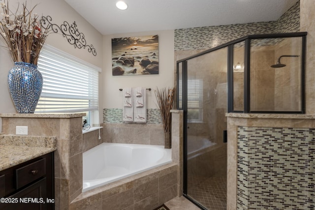 full bathroom featuring a stall shower, a garden tub, and vanity