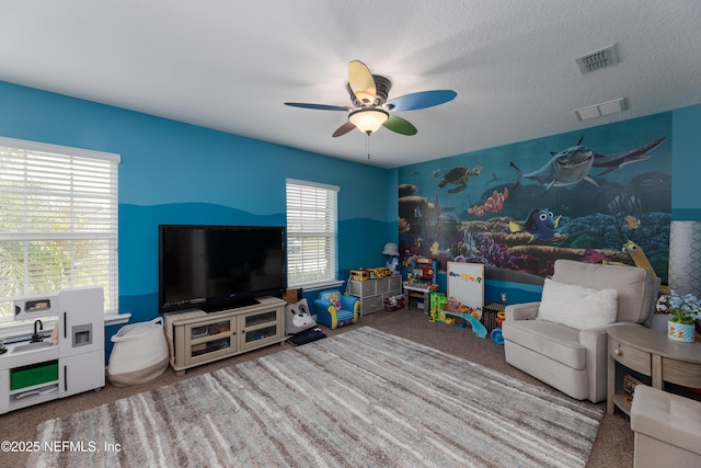 interior space featuring carpet, visible vents, ceiling fan, and a textured ceiling