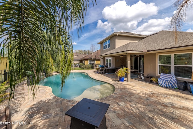 outdoor pool with a ceiling fan, a patio area, fence, and grilling area