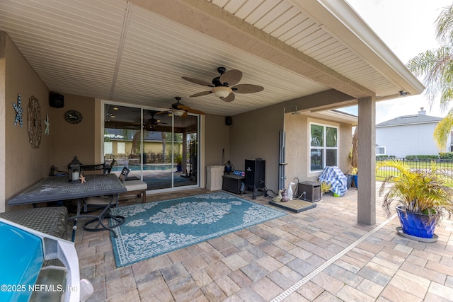 view of patio featuring ceiling fan and fence