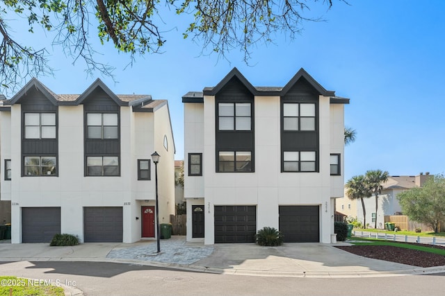 view of front of house with driveway, an attached garage, and stucco siding