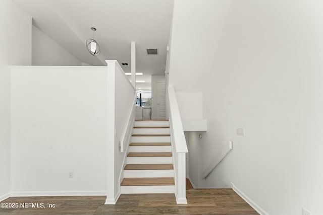 stairs with wood finished floors, visible vents, and baseboards