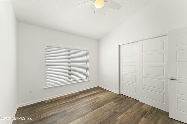 unfurnished bedroom with dark wood finished floors, a ceiling fan, vaulted ceiling, a textured ceiling, and a closet