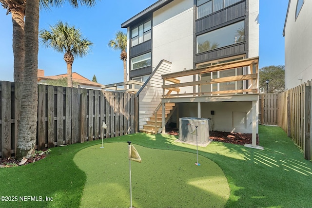 back of house with stairs, central AC unit, and a fenced backyard