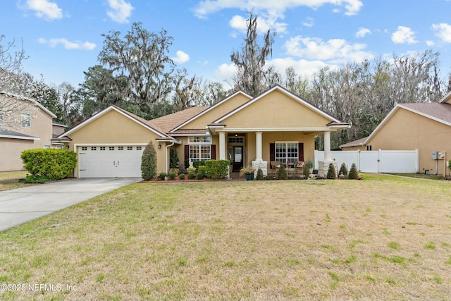 view of front facade featuring an attached garage, a front yard, fence, and stucco siding