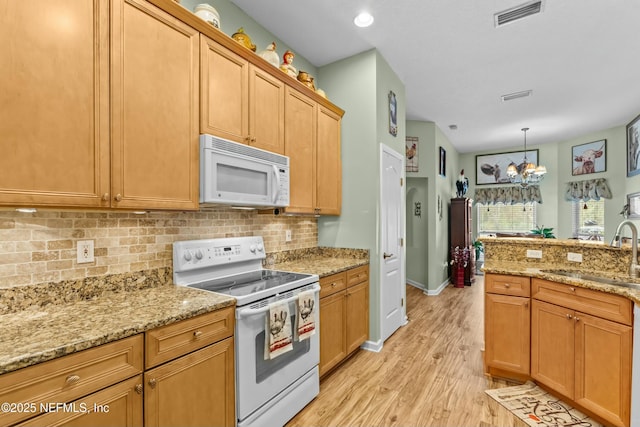 kitchen featuring white appliances, tasteful backsplash, visible vents, light wood-style floors, and a sink