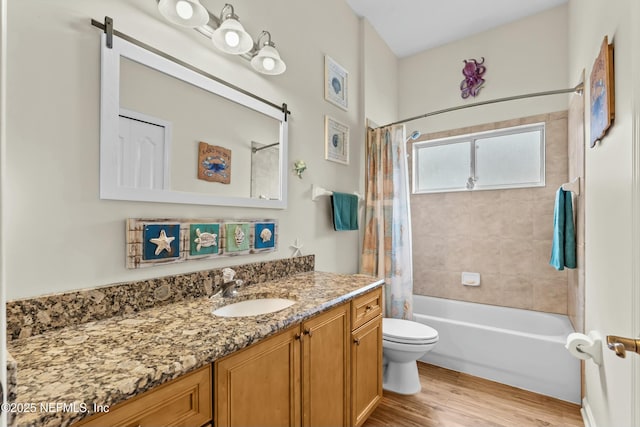 full bathroom with toilet, shower / bath combo, wood finished floors, and vanity