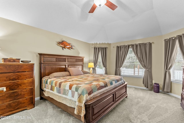 bedroom with light carpet, vaulted ceiling, baseboards, and multiple windows