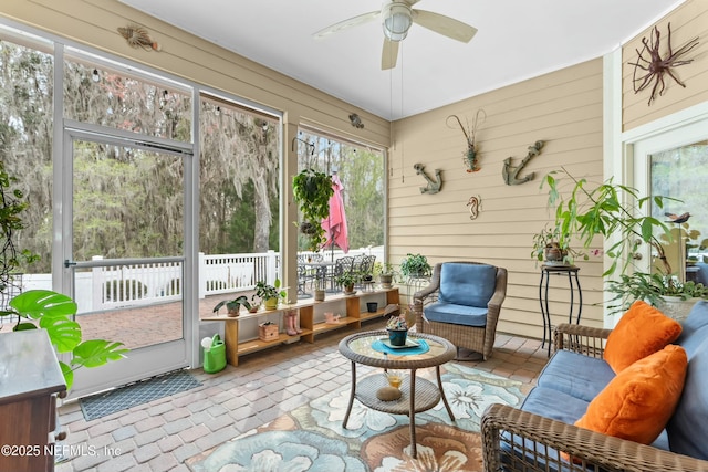 sunroom / solarium featuring a ceiling fan