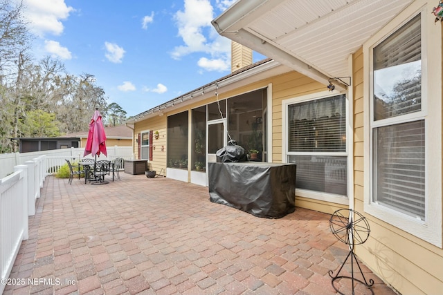 view of patio / terrace featuring a sunroom, outdoor dining area, and a fenced backyard