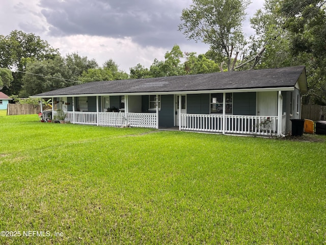 ranch-style house featuring a porch, a front yard, and fence