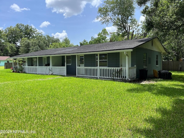 ranch-style home with covered porch, a front yard, and fence