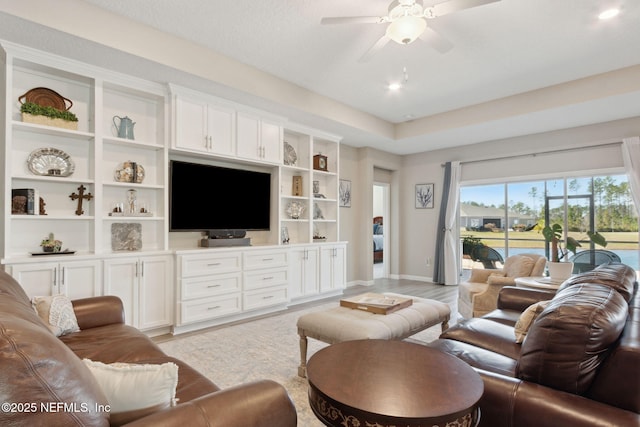 living room featuring light wood-style floors, baseboards, and a ceiling fan