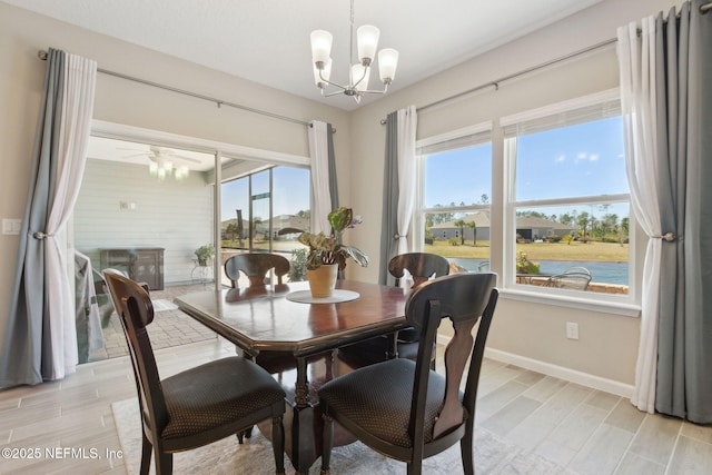 dining space with baseboards, a chandelier, and wood finish floors