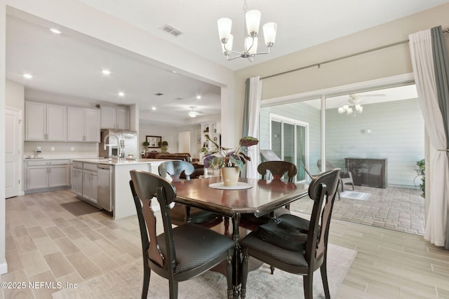 dining area with a chandelier, wood finish floors, visible vents, and recessed lighting