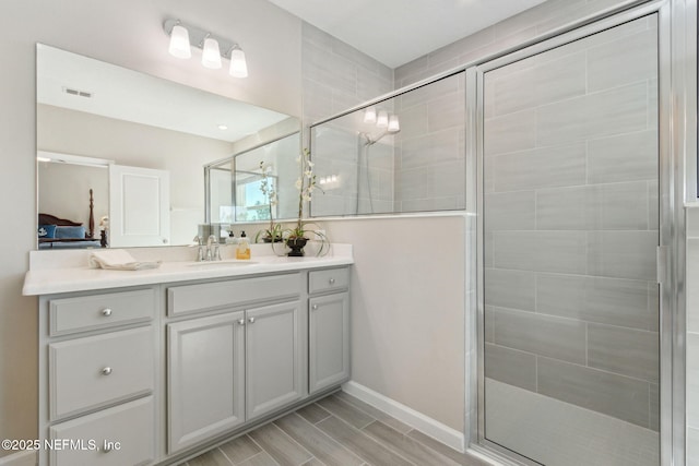 ensuite bathroom with a shower stall, visible vents, connected bathroom, and vanity