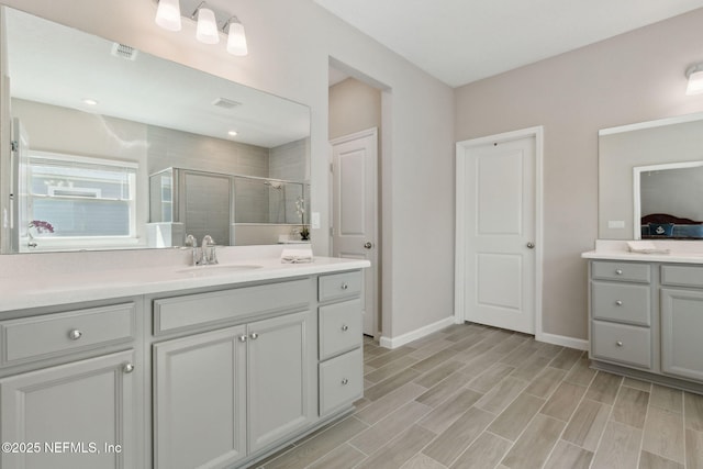 bathroom featuring a shower stall, visible vents, baseboards, and vanity