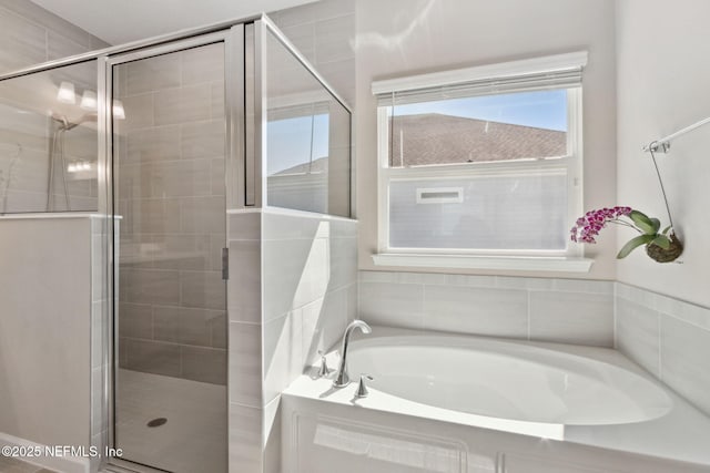 full bathroom featuring a garden tub and a shower stall