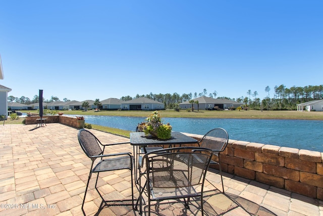 view of patio featuring outdoor dining area and a water view