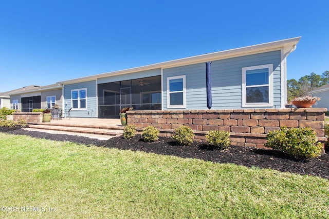 back of house with a patio, a lawn, and a sunroom