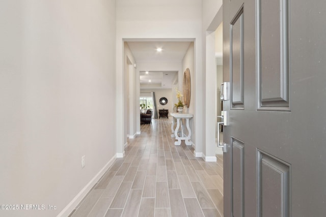 hall featuring wood finish floors and baseboards