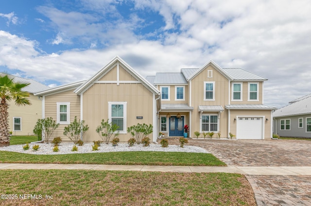 view of front of house featuring a standing seam roof, metal roof, decorative driveway, and board and batten siding