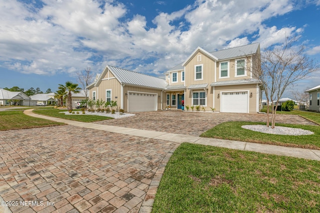 view of front of property featuring a garage, metal roof, a standing seam roof, decorative driveway, and board and batten siding