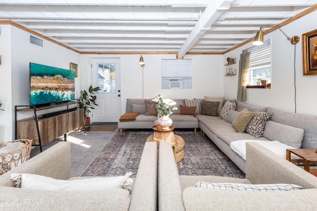 living room featuring beam ceiling, plenty of natural light, cooling unit, and visible vents