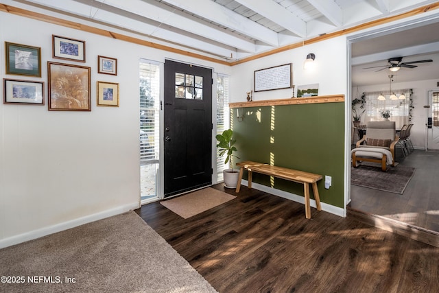 entrance foyer featuring ceiling fan, beam ceiling, baseboards, and dark wood-type flooring