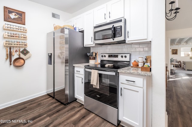 kitchen with baseboards, dark wood finished floors, appliances with stainless steel finishes, white cabinetry, and backsplash