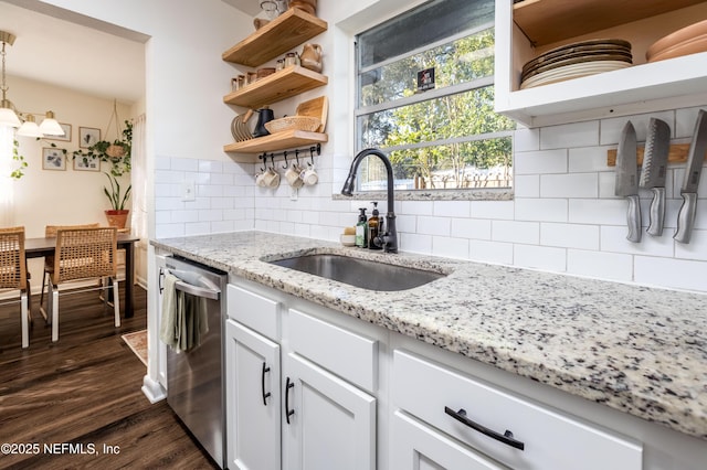 kitchen with open shelves, stainless steel dishwasher, dark wood-type flooring, white cabinetry, and a sink