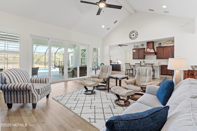 living room featuring light wood-type flooring, visible vents, plenty of natural light, and beamed ceiling