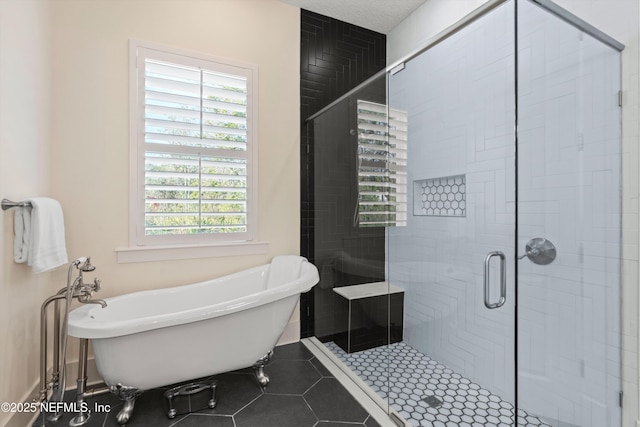 full bathroom featuring a freestanding bath, a stall shower, and tile patterned floors