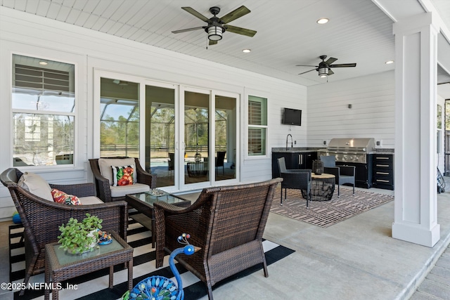 view of patio featuring an outdoor kitchen, area for grilling, outdoor lounge area, a sink, and a ceiling fan