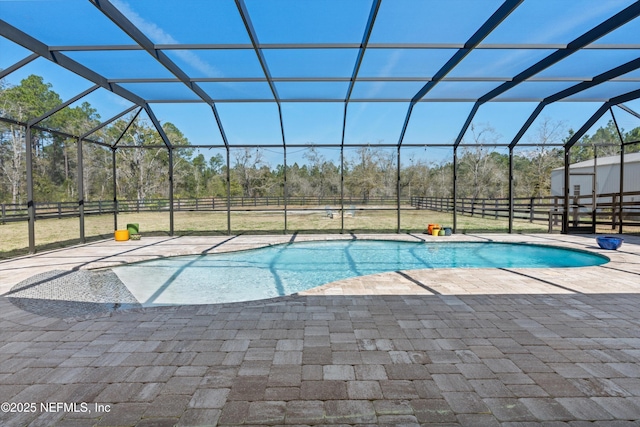 pool featuring a lanai, a patio, and fence