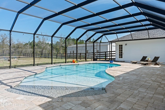 outdoor pool featuring glass enclosure and a patio