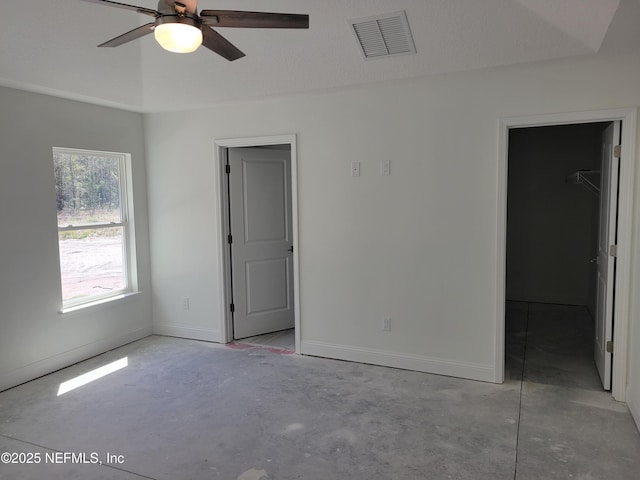 spare room featuring visible vents, ceiling fan, unfinished concrete flooring, and baseboards